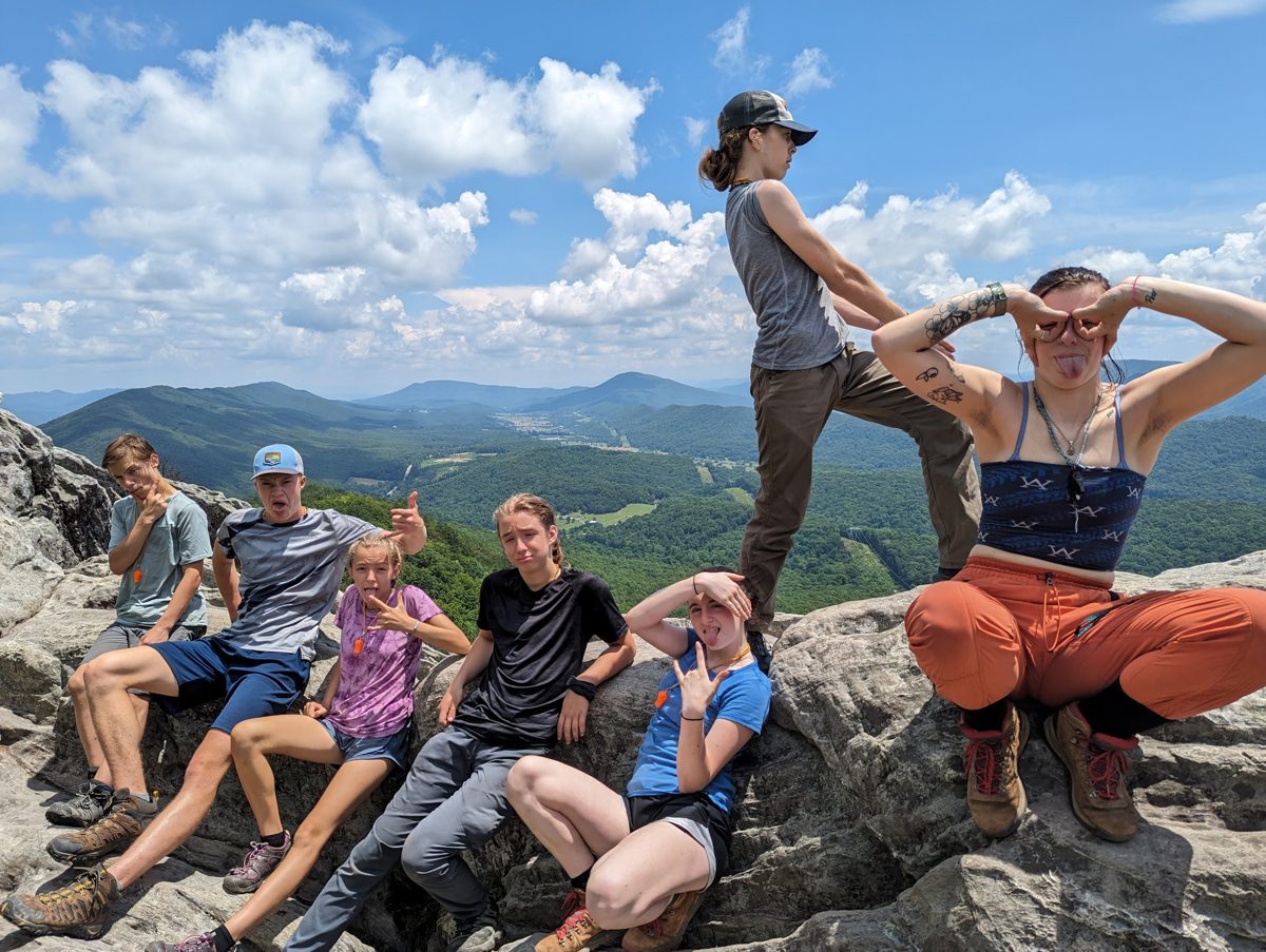 Campers laughing together on a rocky mountain overlook