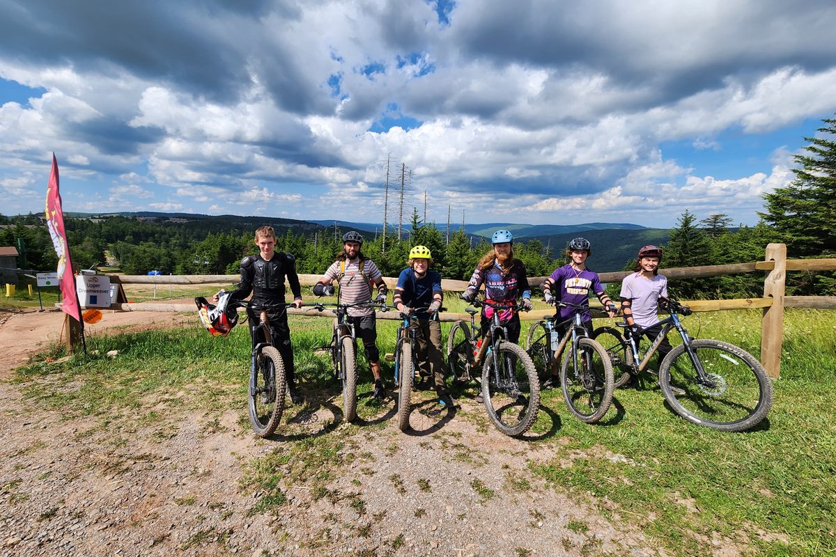 Campers lined up with their mountain bikes at a ridge-top trailhead