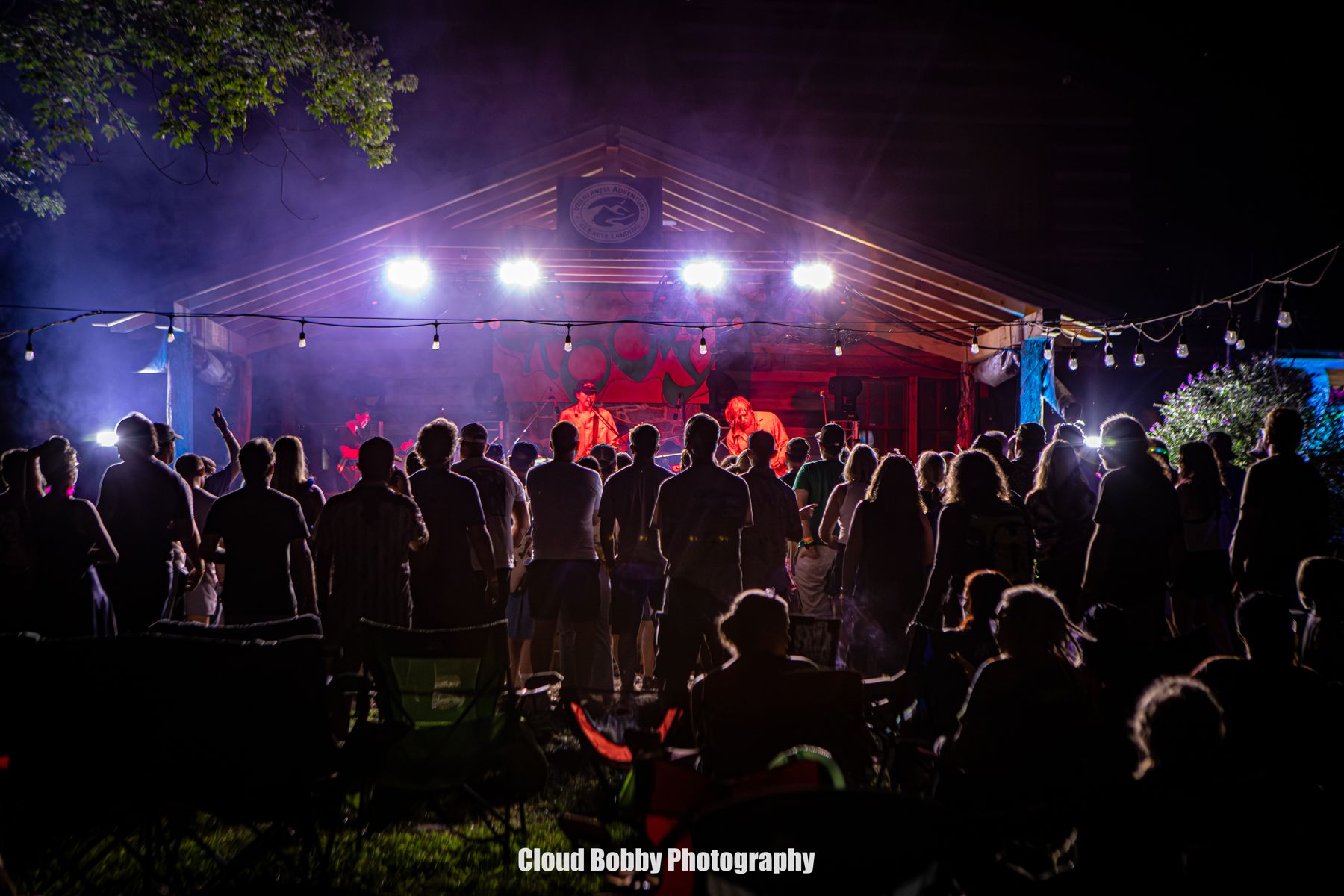 Festival guests watching a band beneath bright stage lights at WA Fest