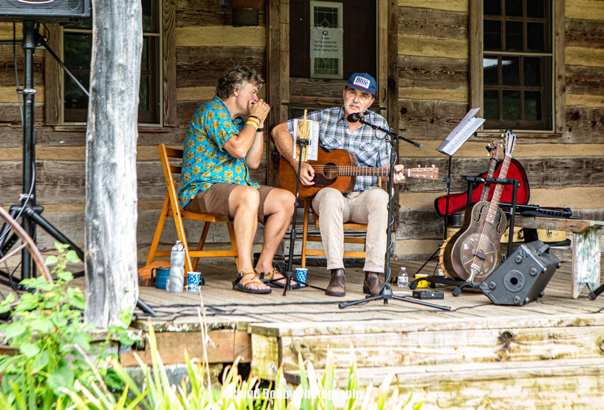 Musicians playing an acoustic set on a wooden porch