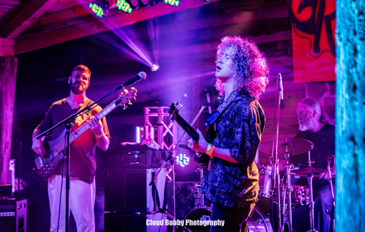 Musicians performing under purple lights on the WA Fest stage
