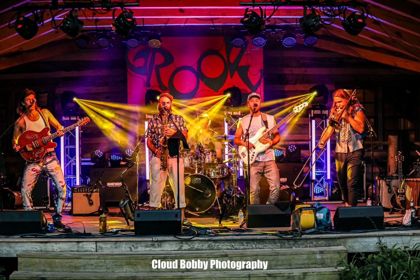 A band performing under colorful stage lights at Wilderness Adventure