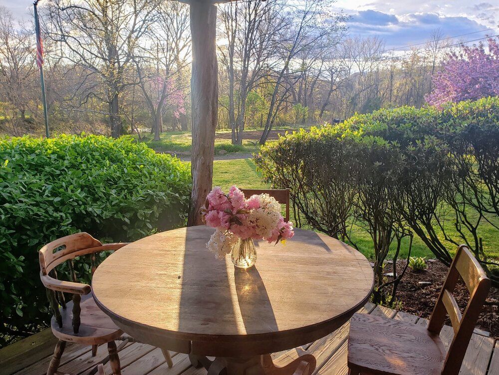 A round table on the lodge porch overlooking the green mountain valley