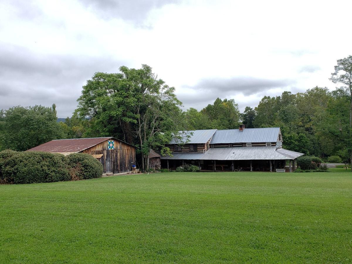The log Main Lodge across a wide green lawn