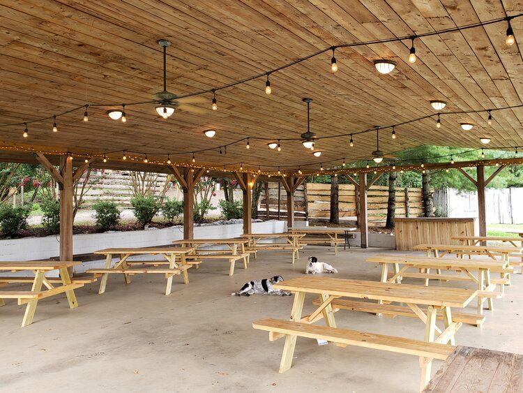 Picnic tables under the timber roof of the outdoor pavilion