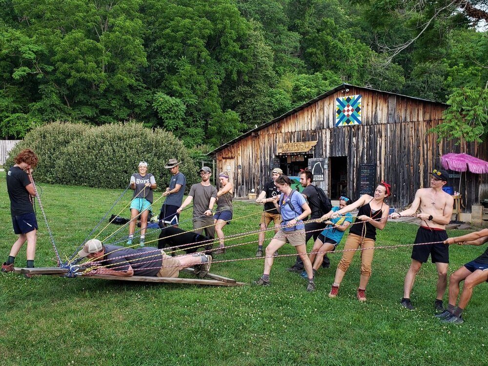 A group working together on a rope and platform challenge at Wilderness Adventure