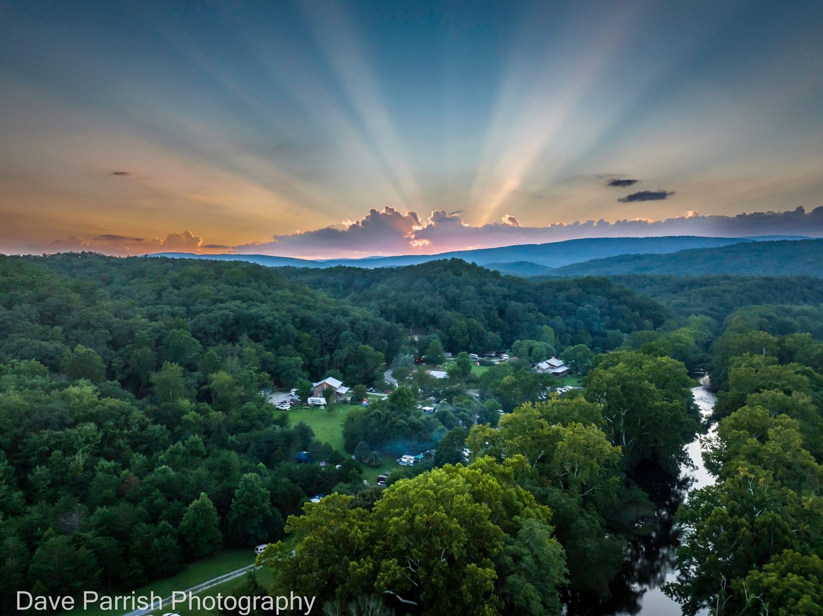 Sun rays over forested mountain ridges above the Wilderness Adventure property and Craig Creek