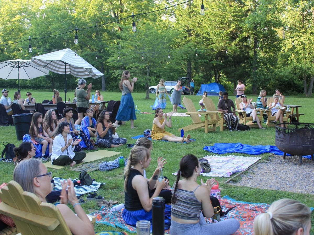 Yoga Venture guests sitting out on blankets and camp chairs for an evening set